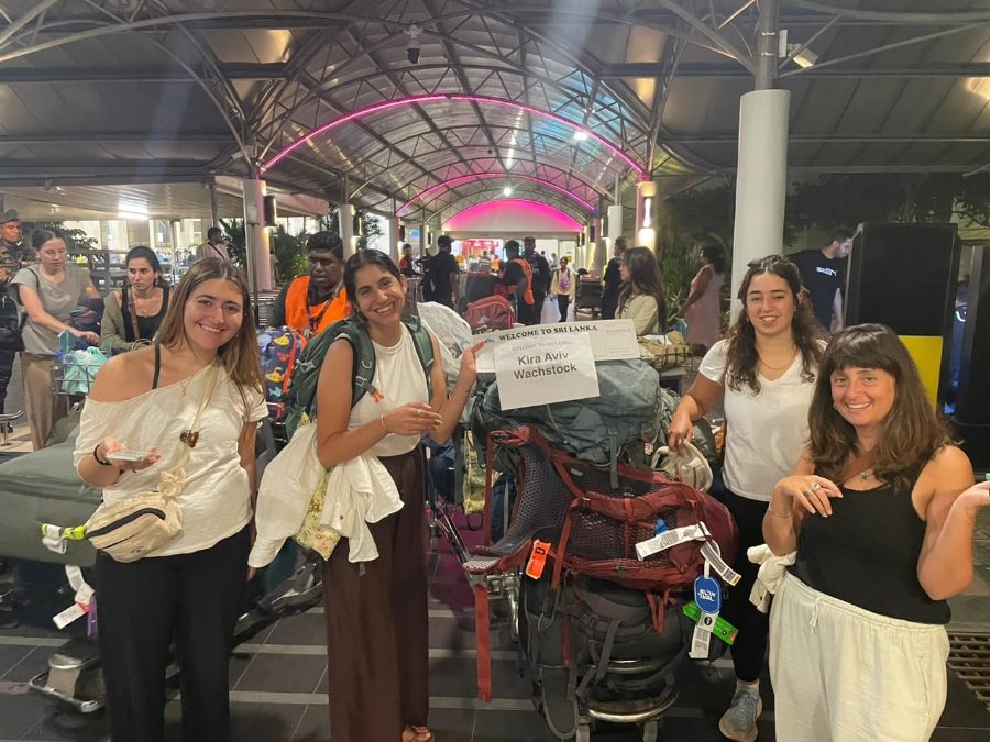 Four travellers with backpacks and a welcome board at Colombo airport arrivals late at night