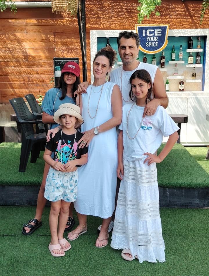 A family standing together at a beach bar on the south coast at the end of their tour