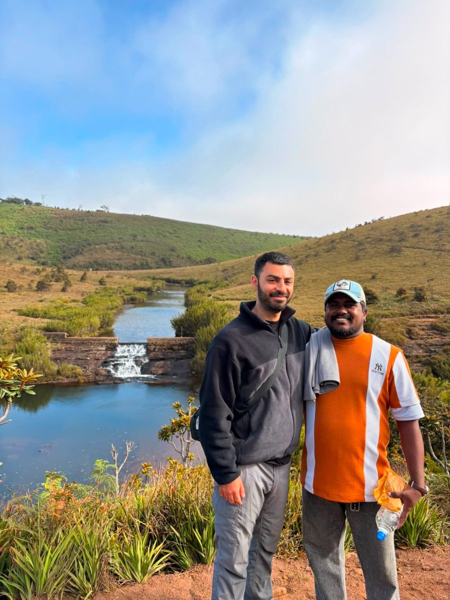 A guest and his driver-guide beside a small waterfall on the open grassland of the Horton Plains